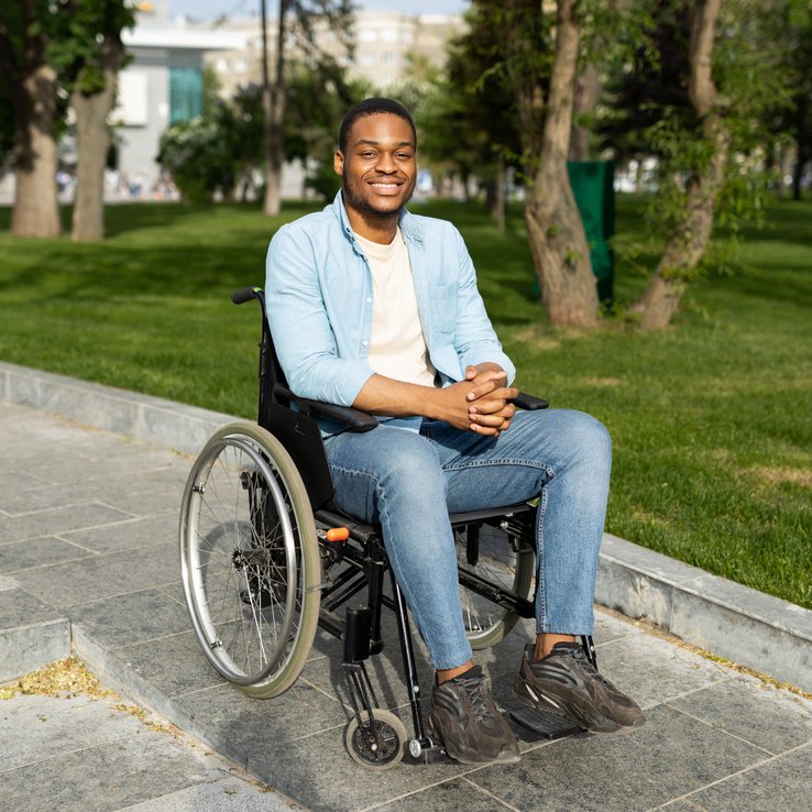 Smiling man in a wheelchair on the sidewalk